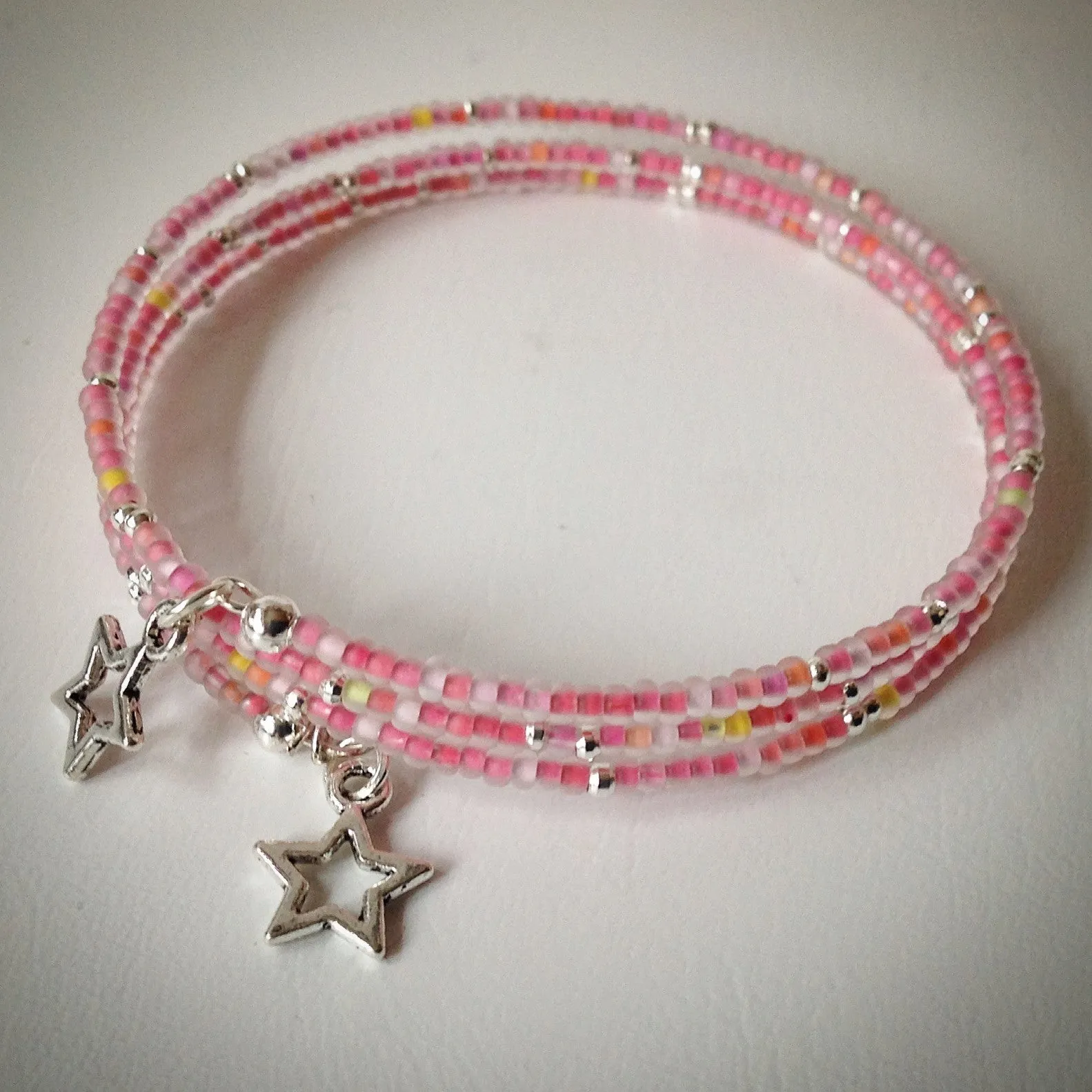 Beaded memory wire bracelet - silver and pink frosted seed beads and star pendants