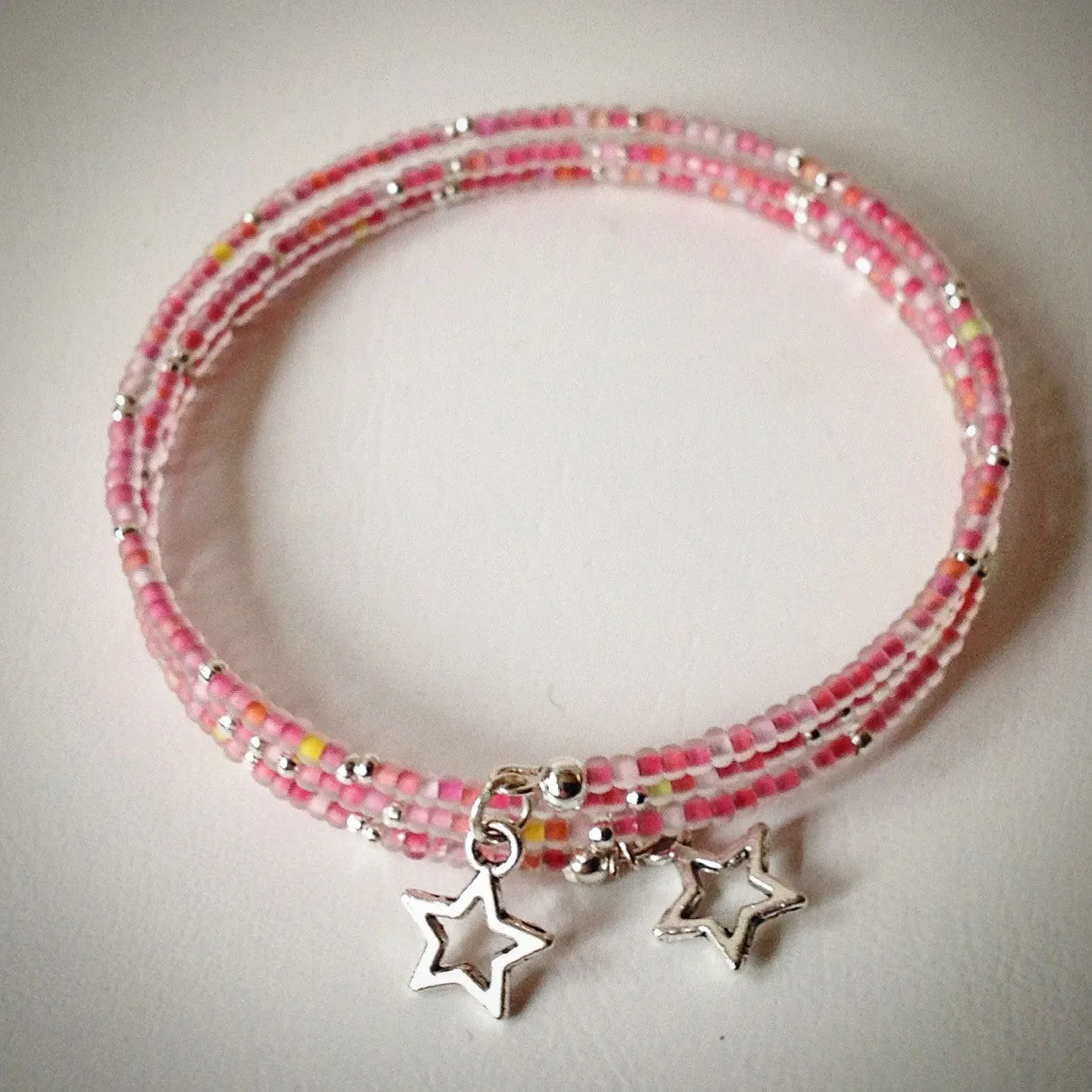 Beaded memory wire bracelet - silver and pink frosted seed beads and star pendants